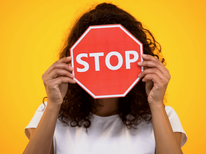 Femme tenant un panneau stop